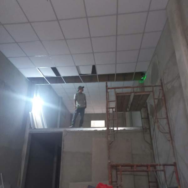 Công nhân đang đóng trần thạch cao thả cho nhà gác lửng
