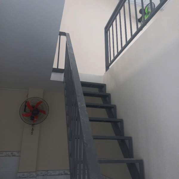 Cầu thang sắt dẫn lên gác lửng trong phòng trọ mini mới cải tạo