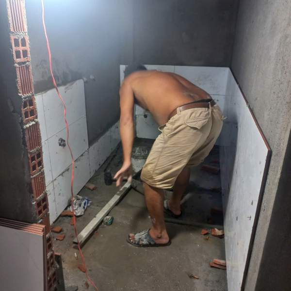 •Công nhân đang thi công phần nền toilet mới trong nhà cũ.